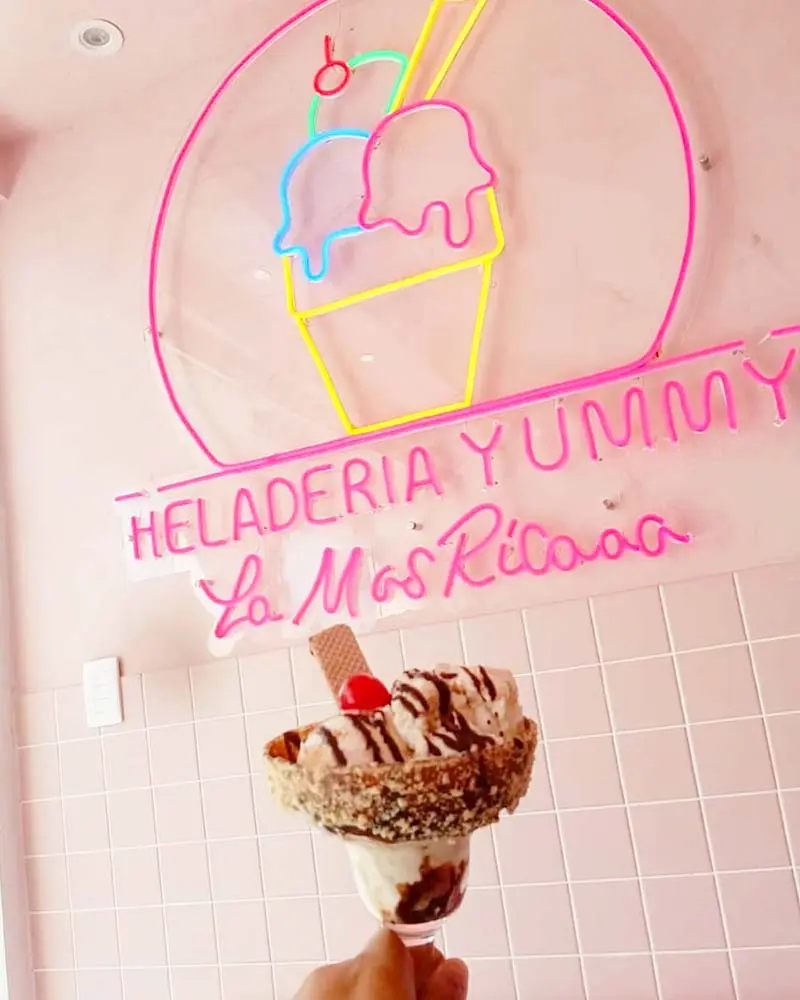 Dessert in front of a neon sign at Heladeria Yummy